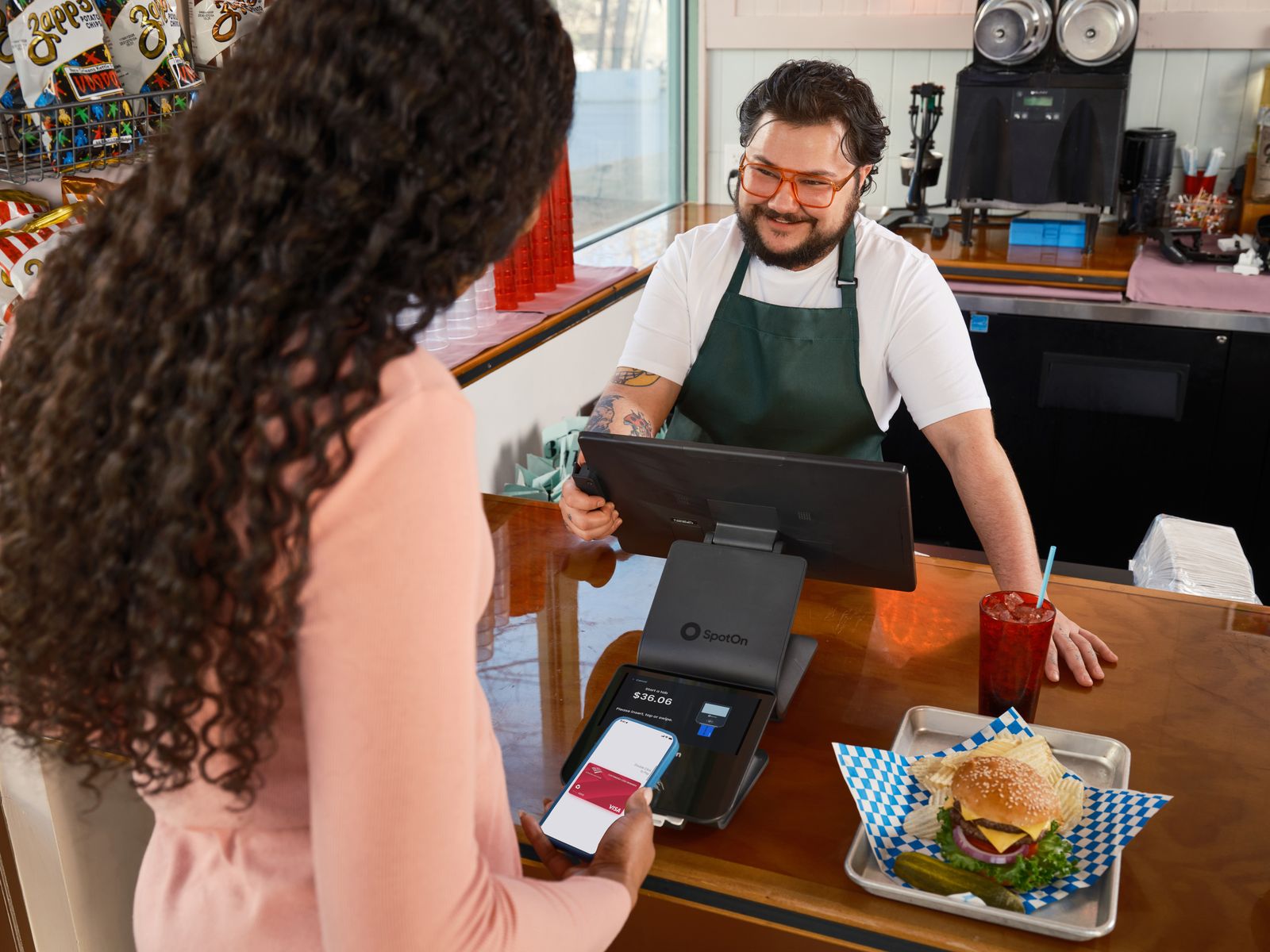 Customer making a contactless payment at a cafe counter